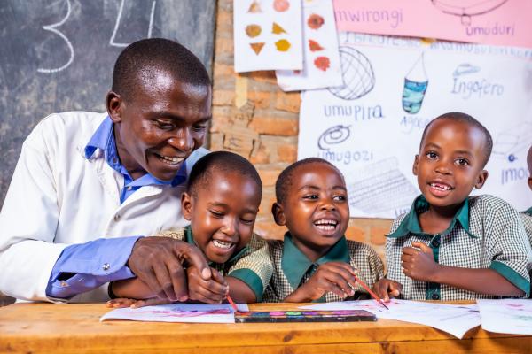 Rwanda Education Lets Learn Through Play TMR Lego Smiling school children and teacher learning letters 2024